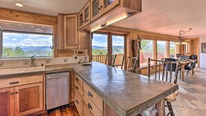 Keittiössä on puiset kaapit, suuri keittiösaareke ja ikkunoista avautuu näkymä vuorille.