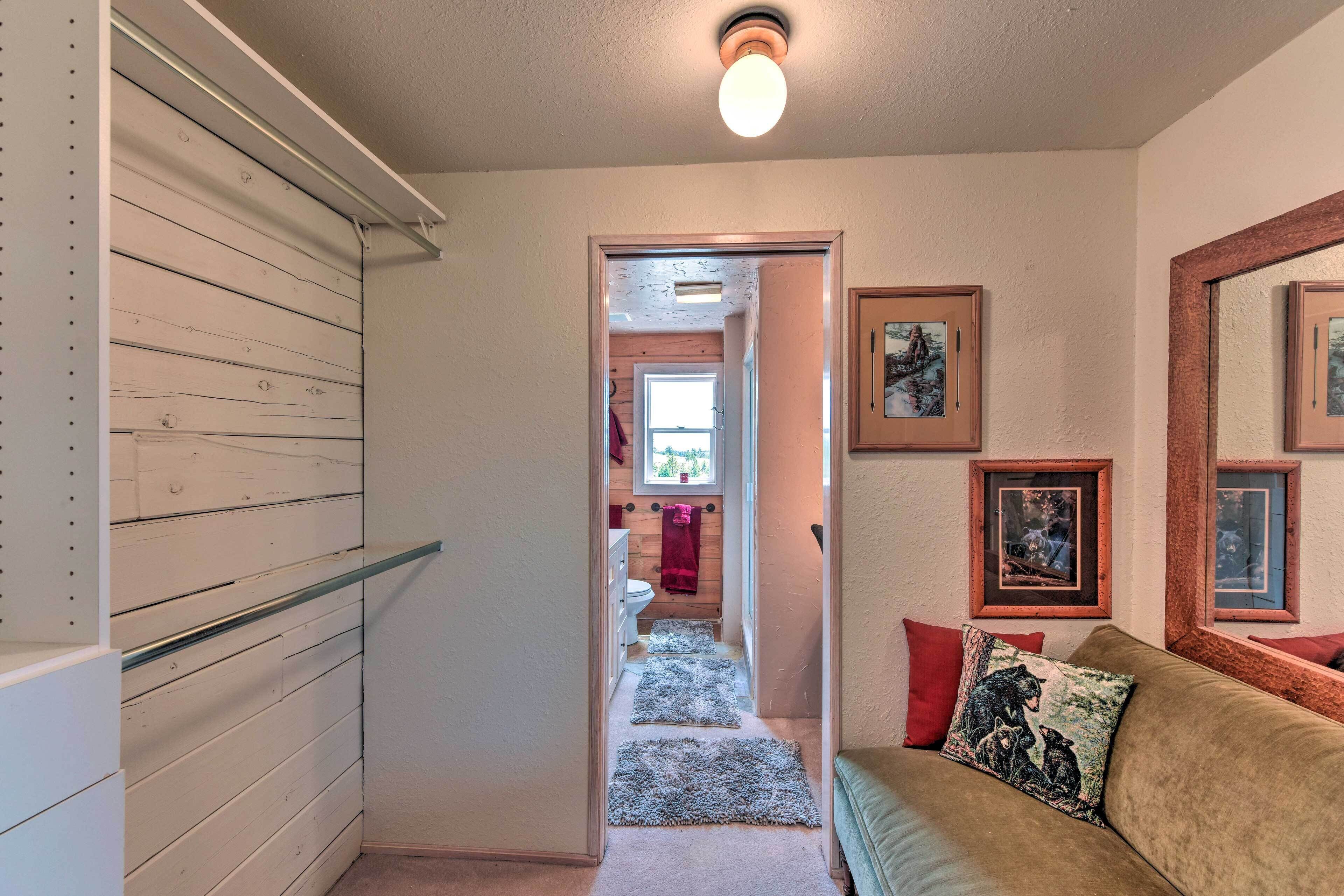A hallway with a wooden wall, a glass shelf, a red towel, and a framed picture on the wall.