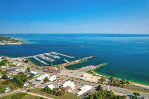 Vista aérea de una zona costera con un puerto deportivo, una carretera y edificios.