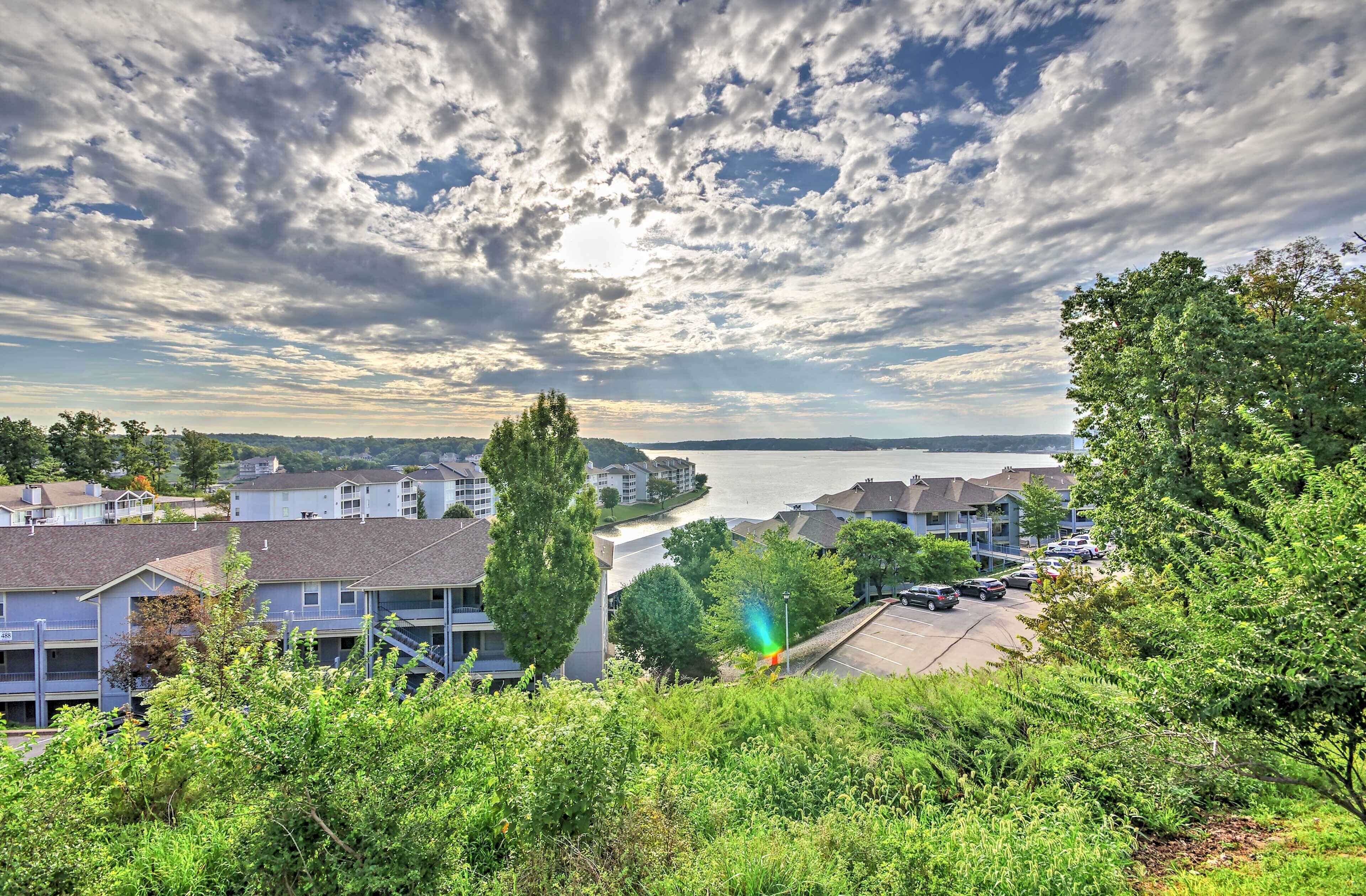 Quartiere residenziale con case, un parcheggio e uno specchio d'acqua sullo sfondo.
