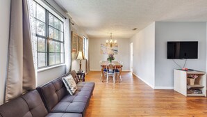 Un salon moderne avec un canapé, une table à manger et un téléviseur.
