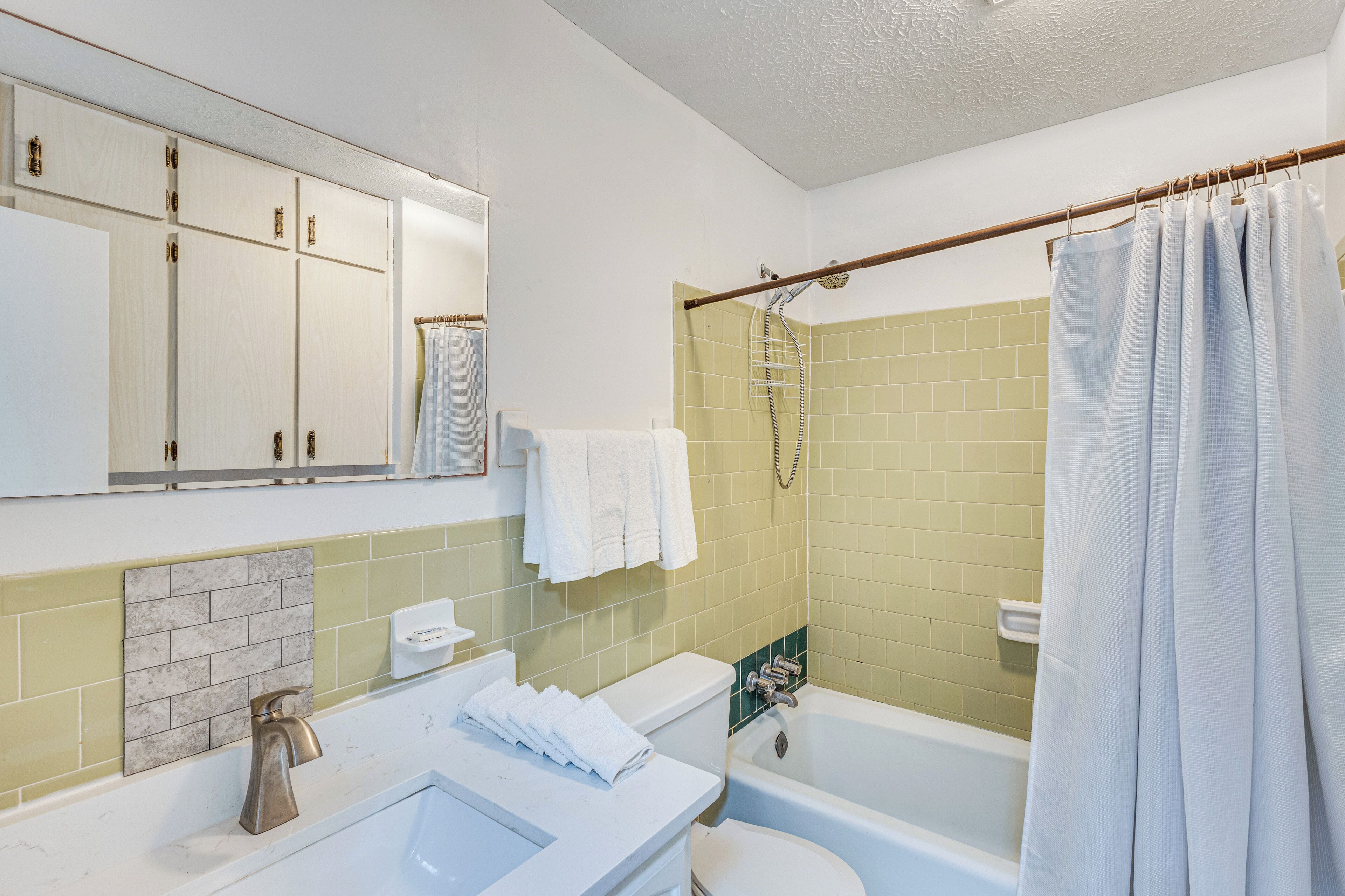 A bathroom with a white sink, a toilet, a bathtub, and a shower.