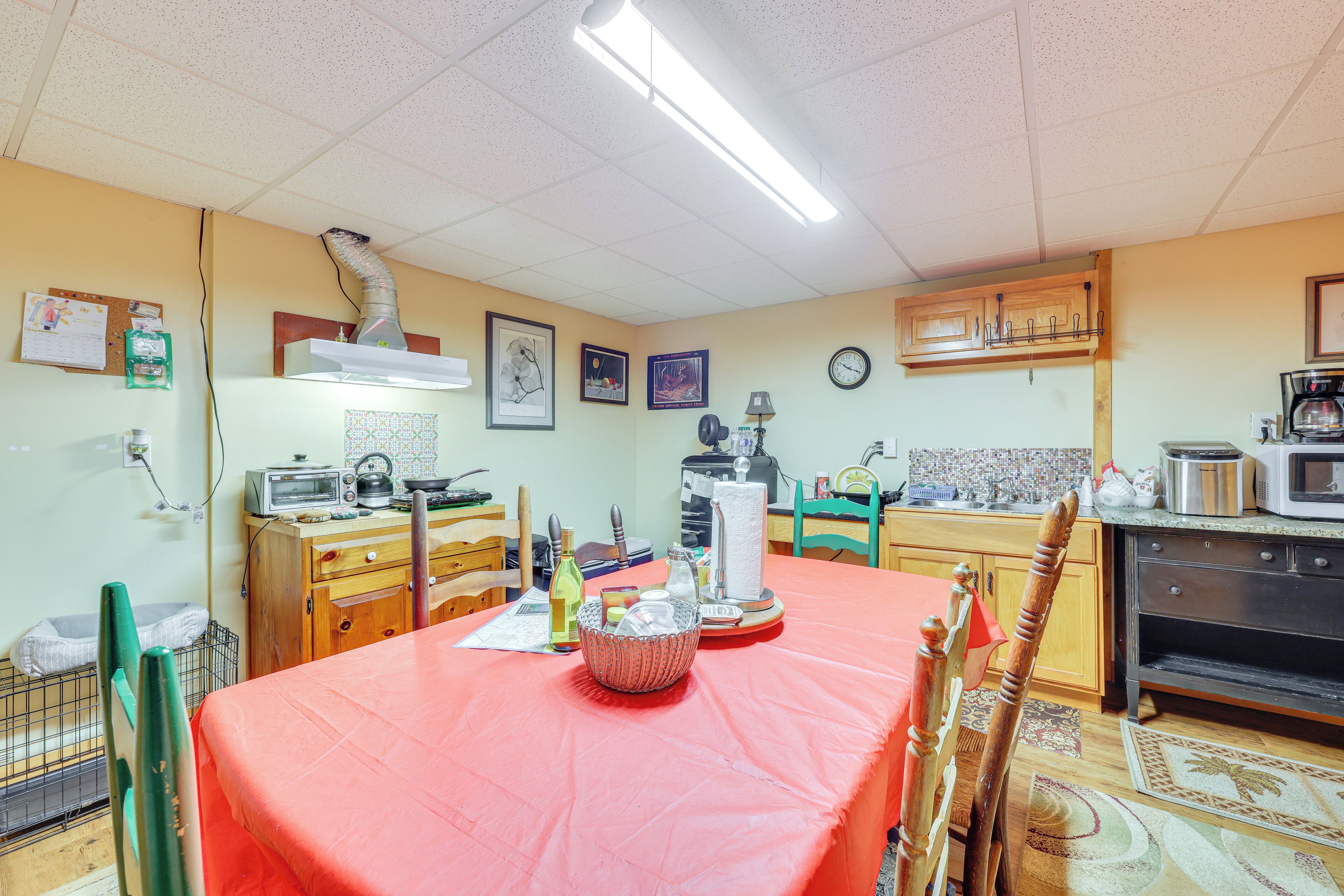 A kitchen with a dining table, chairs, a microwave, a stove, and various kitchen appliances.