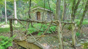 A rustic stone structure with a wooden door, surrounded by a forest. - Georgia Home w/ 2 Fire Pits & Creek Access! (Young Harris)