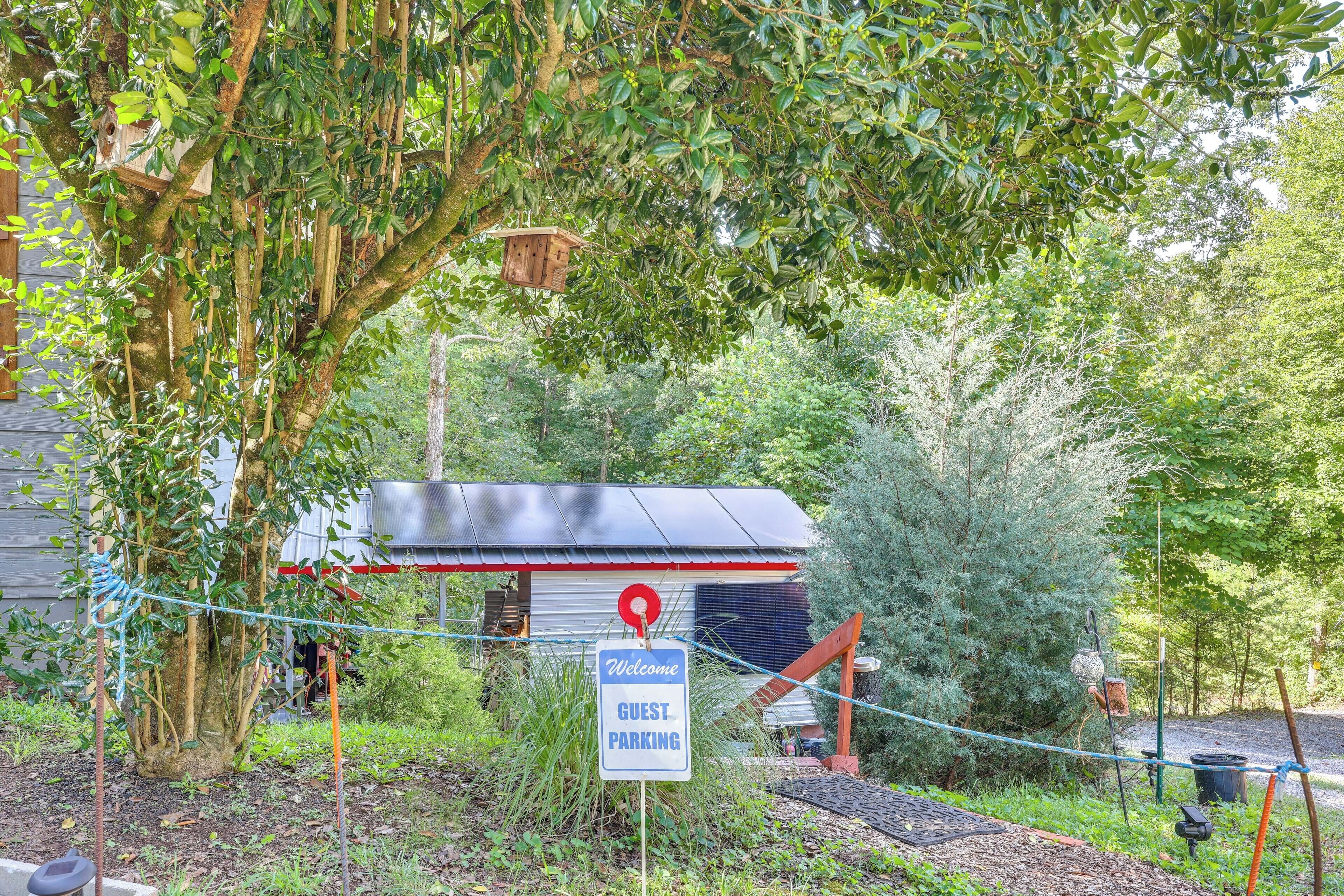 A guest parking area with a sign indicating 'Welcome Guest Parking' and a small building with a metal roof.