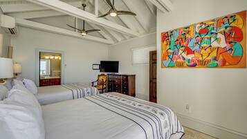 A hotel room with two beds, a ceiling fan, a large abstract painting, a television, and a wooden dresser.