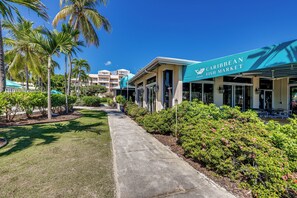 Un chemin menant à un bâtiment sur lequel est apposée une enseigne indiquant : « Marché aux poissons des Caraïbes ».