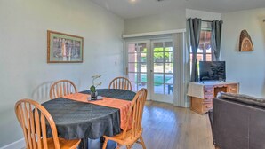 A dining area with a table set for four, wooden chairs, a ceiling fan, and a television on a wooden cabinet. - Rejuvenating Retreat w/ Ideal Eloy Location! (Eloy)
