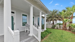 A white house with a porch, green shutters, and a white fence. - Sea Breeze Cottage - Private Home At The Shores 3 Bedroom Home (South Padre Island)