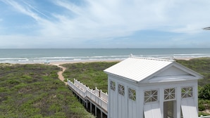 A white building with a balcony overlooking a beach and ocean. - Sea Breeze Cottage - Private Home At The Shores 3 Bedroom Home (South Padre Island)