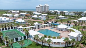 A resort with multiple buildings, a tennis court, a swimming pool, and a view of the ocean. - Sea Breeze Cottage - Private Home At The Shores 3 Bedroom Home (South Padre Island)