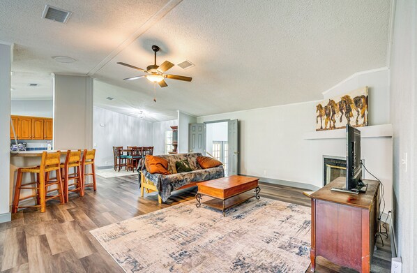 Cozy living area with a high ceiling, dining table, sofa, and fireplace.