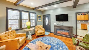 A living room with a fireplace, leather armchairs, a coffee table, and a television. - 13 Mi to Skiing: Downtown Wallace Home w/ Deck (Wallace)