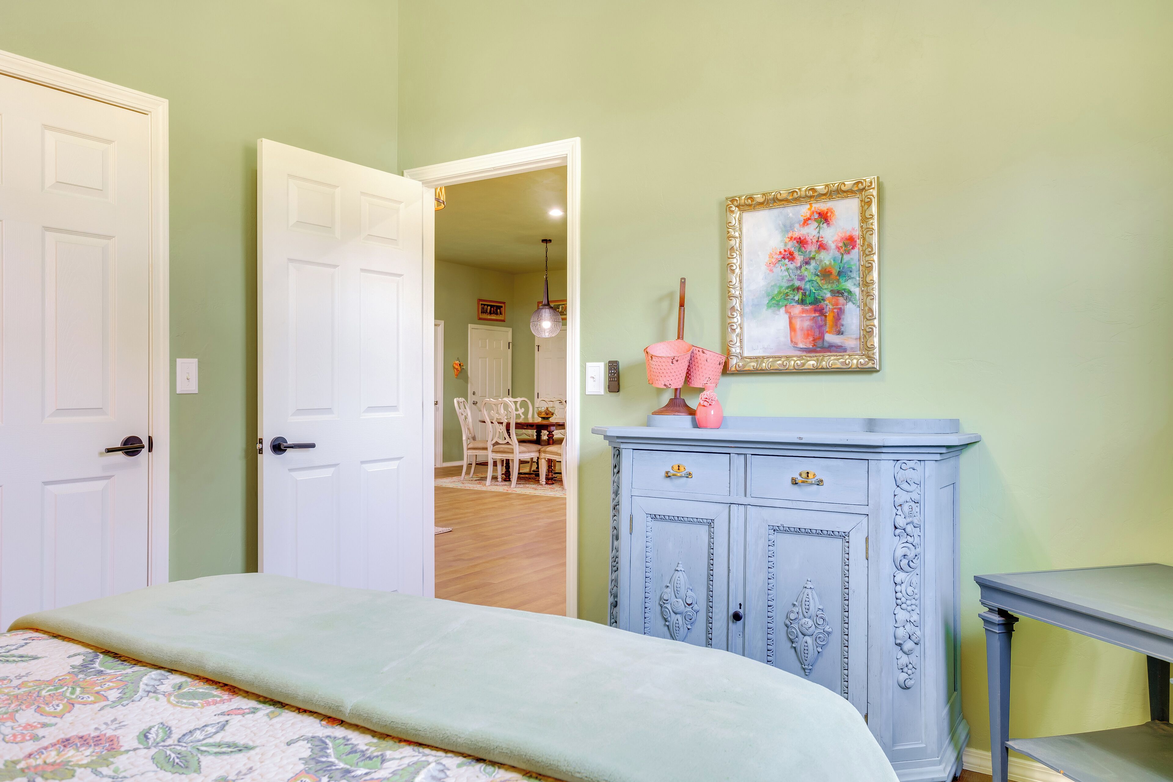 Un dormitorio con cama, cómoda y mesa.