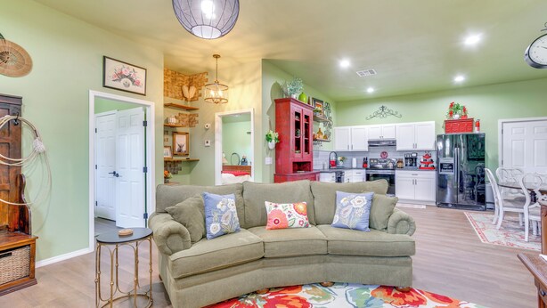 A living room with a sectional sofa, a small side table, and a colorful rug. - 4 Mi to Lazy E Arena: Horse Lover's Haven w/ Grill (Guthrie)