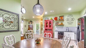 A dining area with a wooden table and chairs, a decorative bowl, and a hanging light fixture. - 4 Mi to Lazy E Arena: Horse Lover's Haven w/ Grill (Guthrie)