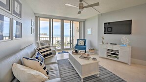 Un soggiorno con divano, tavolino da caffè e mobile TV. È presente un balcone con vista.