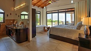 Un'ampia camera da letto con un letto grande, una toeletta con specchio e vista sull'esterno.