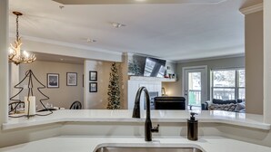 Una cocina moderna con un lavamanos de acero inoxidable, una araña y un árbol de Navidad.