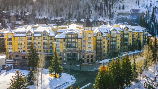 A large yellow hotel with multiple floors and a central courtyard. - Ritz Carlton Vail #402 4 Bedroom Condo (Vail)
