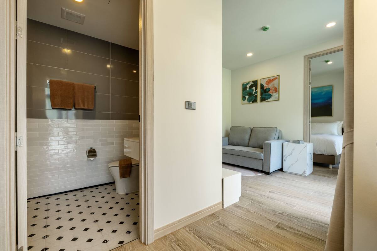 Un baño moderno con inodoro, toallero y suelo estampado.