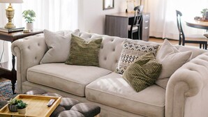 A living room with a beige sofa, a wooden coffee table, and a patterned rug. - Sunset Serenity Suite (Myerstown)