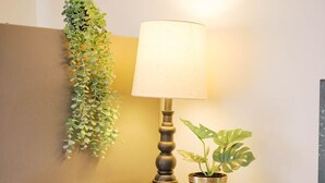 A kitchenette with a microwave, a wooden cabinet, a small plant, a lamp, and a decorative basket. - Sunset Serenity Suite (Myerstown)