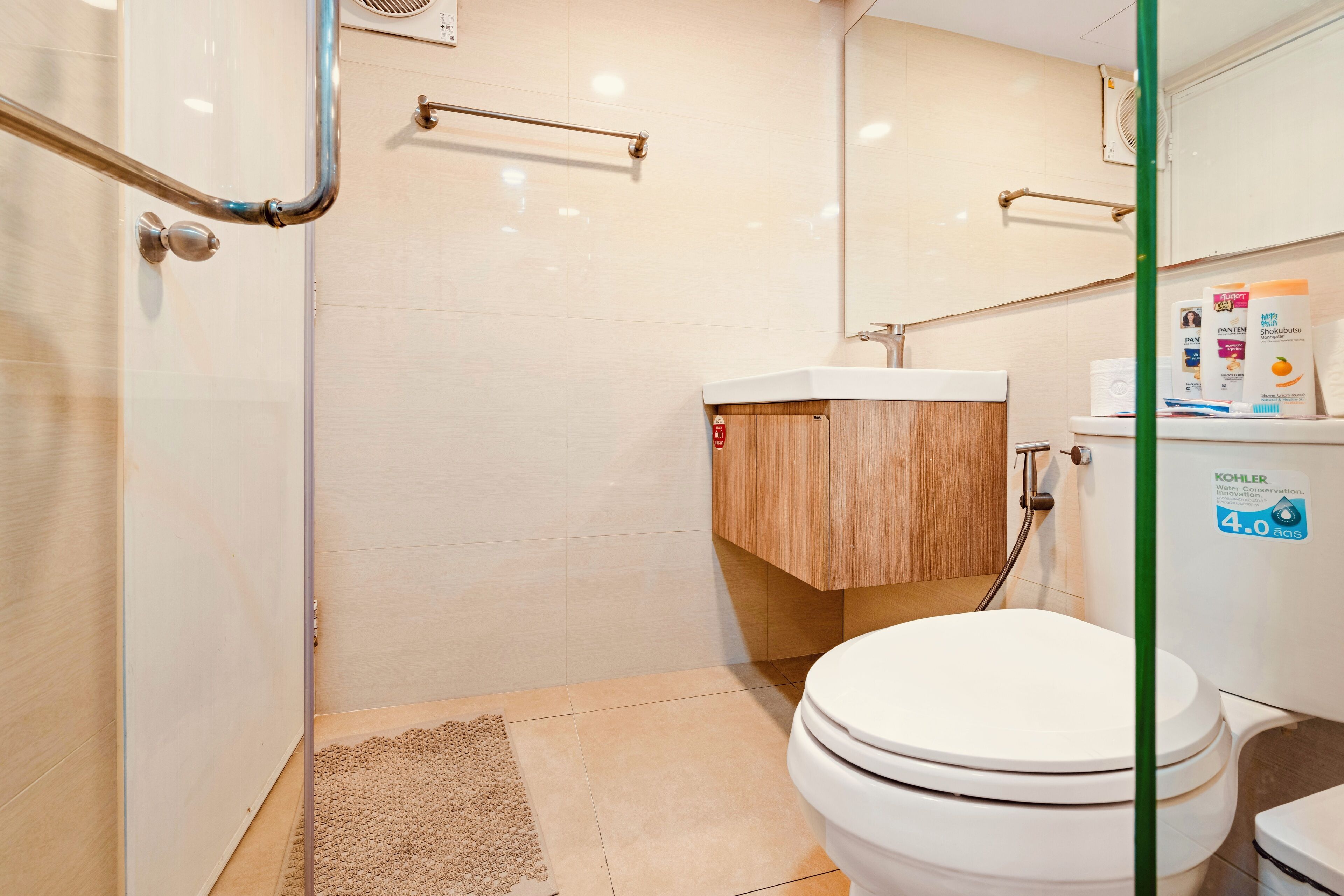A modern bathroom with a shower, toilet, and sink.