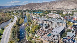 A hotel complex with multiple buildings, a river, and a mountainous backdrop.