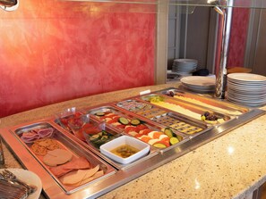A buffet with various food options including meats, cheeses, fruits, and vegetables. - Donauhotel Ingolstadt (Ingolstadt)