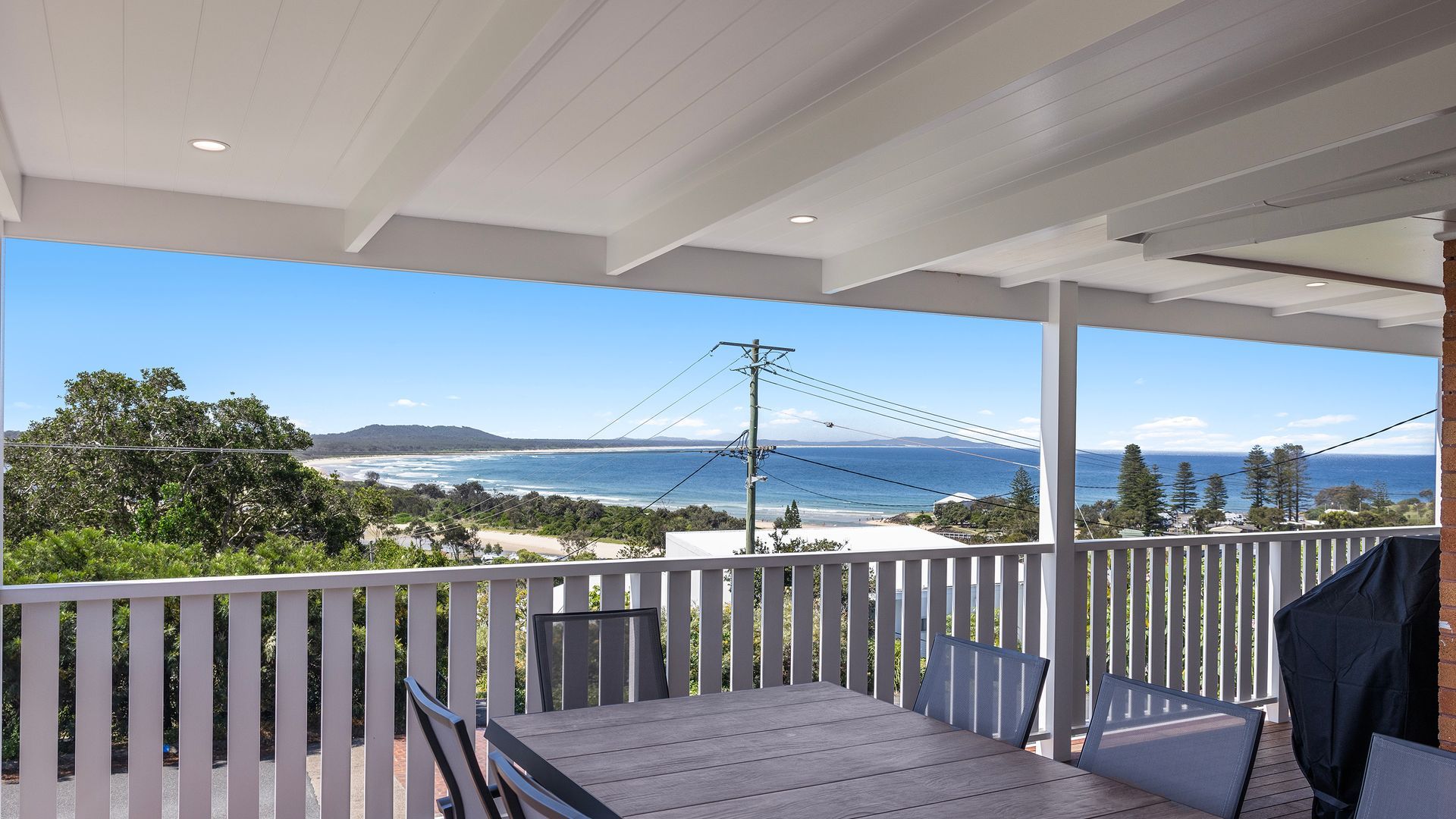 A covered outdoor area with a view of the ocean and beach.