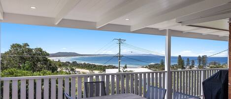 A covered outdoor area with a view of the ocean and beach.