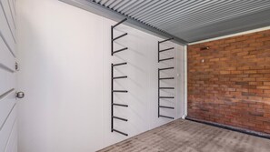 Une porte fermée, avec un intérieur blanc et un système de rayonnages métalliques fixé au mur.