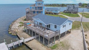 A coastal house with a deck, a small pool, and a view of the ocean. - Soundfront Home in Frisco with Hot Tub, Private Dock and Windsurfing Access (Frisco)