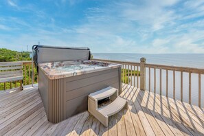 A hot tub on a wooden deck with a view of the ocean. - Soundfront Home w/ Private Windsports Access, Hot Tub, Stunning Views (Waves)