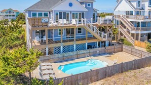 A multi-story beachfront house with a pool, wooden deck, and multiple balconies. - Oceanfront Dog Friendly Home w/ Saltwater Pool, Elevator, Hot Tub, Cmty Perks (Waves)