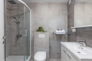 A modern bathroom with a glass shower enclosure, a white toilet, and a white sink. - Modern Home With Swimming Pool and sea View (Crikvenica)