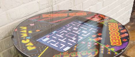 Une barrique en bois surmontée d’une borne d’arcade rétro, avec des graphismes colorés et les inscriptions « DONKEY KONG » et « Rocker ».