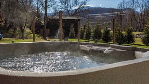 A hot tub surrounded by trees and a wooden structure in a park setting. - Walk Into The National Park/View (Sevierville)