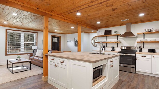 A spacious kitchen with white cabinetry, a central island, and a wooden ceiling. - Walk Into The National Park/View (Sevierville)