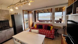 A compact kitchen with a dining area, a sofa, and a TV. - Casa Raffa by Wonderful Italy (Olbia)