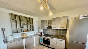 A modern kitchen with stainless steel appliances, a built-in oven, and a large island. - Casa Raffa by Wonderful Italy (Olbia)
