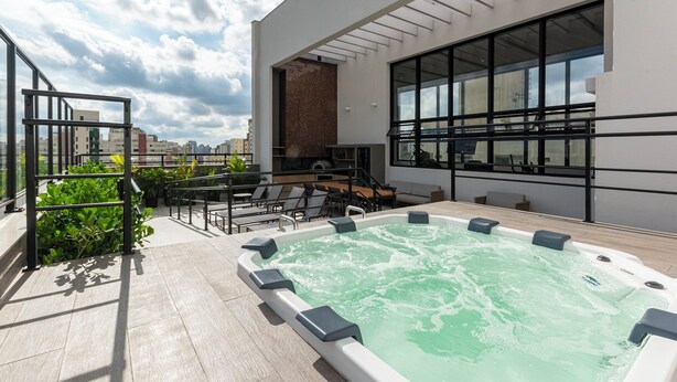 A rooftop pool area with a hot tub, seating, and a city view. - Lexy Hotel (São Paulo)