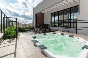 A rooftop pool area with a hot tub, seating, and a city view. - Lexy Hotel (São Paulo)