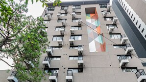 A modern building with multiple balconies, air conditioning units, and a geometric pattern on the facade. - Lexy Hotel (São Paulo)