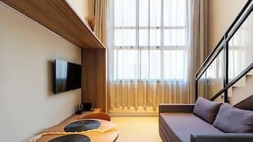 Studio – deluxe, byutsikt | Oppholdsområde | Flatskjerm-TV