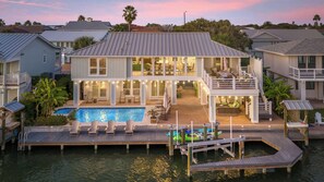 A waterfront house with a pool, outdoor seating, and a dock. - Heated Pool, Hot Tub, Kayaks, Fishing, 5BR Waterfront Home in Key Allegro (Rockport)