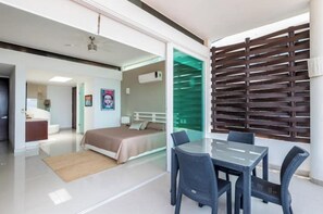 Relax in a spacious room with a large bed, dining area, and partition.