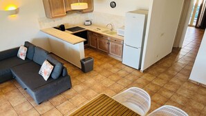 Cocina compacta con comedor, sofá y una pequeña mesa.