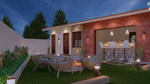 A modern house with a dining area, outdoor lighting, and a well-maintained lawn. - Villa Euphoria (Ootacamund)